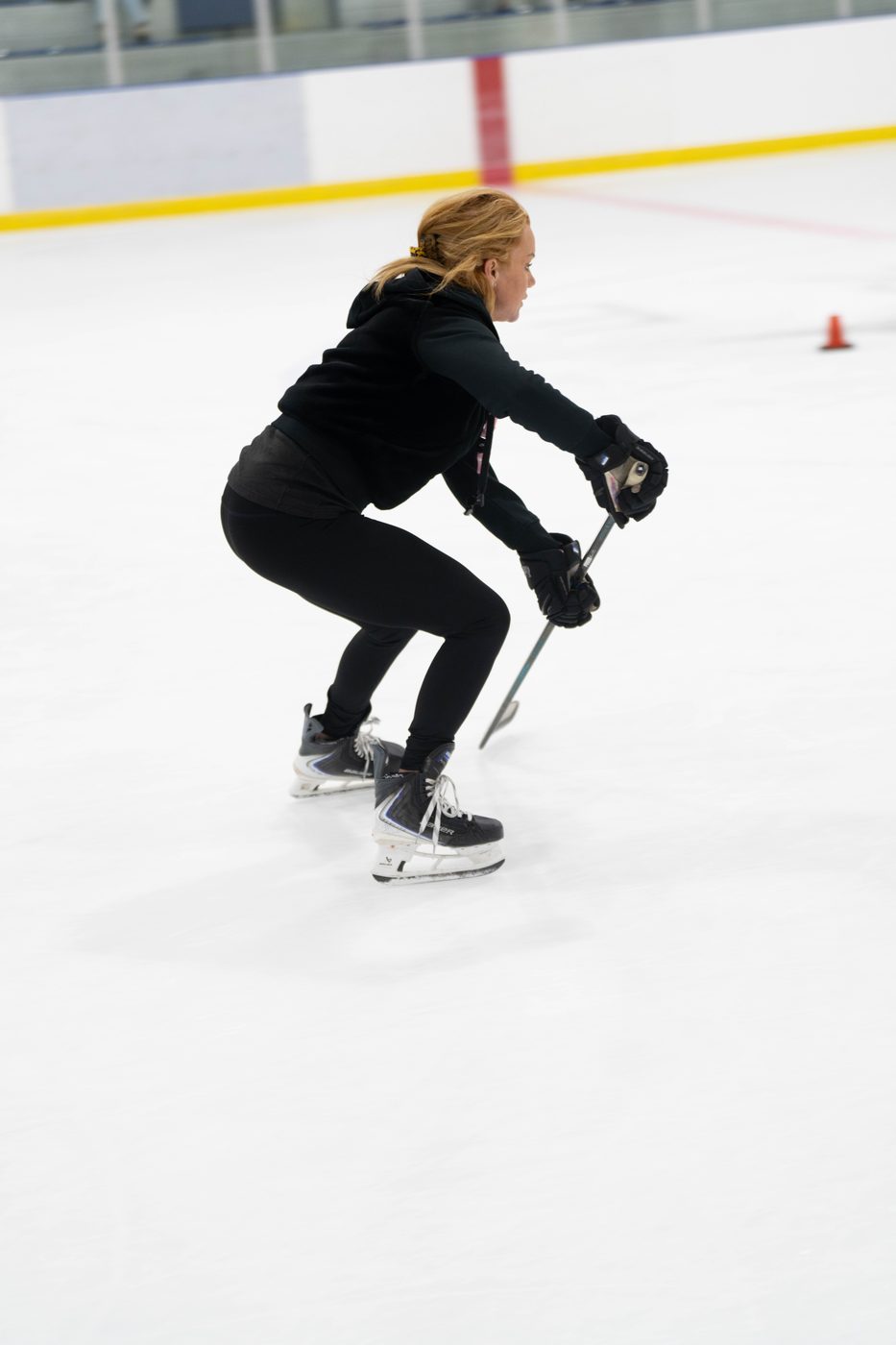 Stacy Allen skating low with both hands on her stick, demonstrating body position